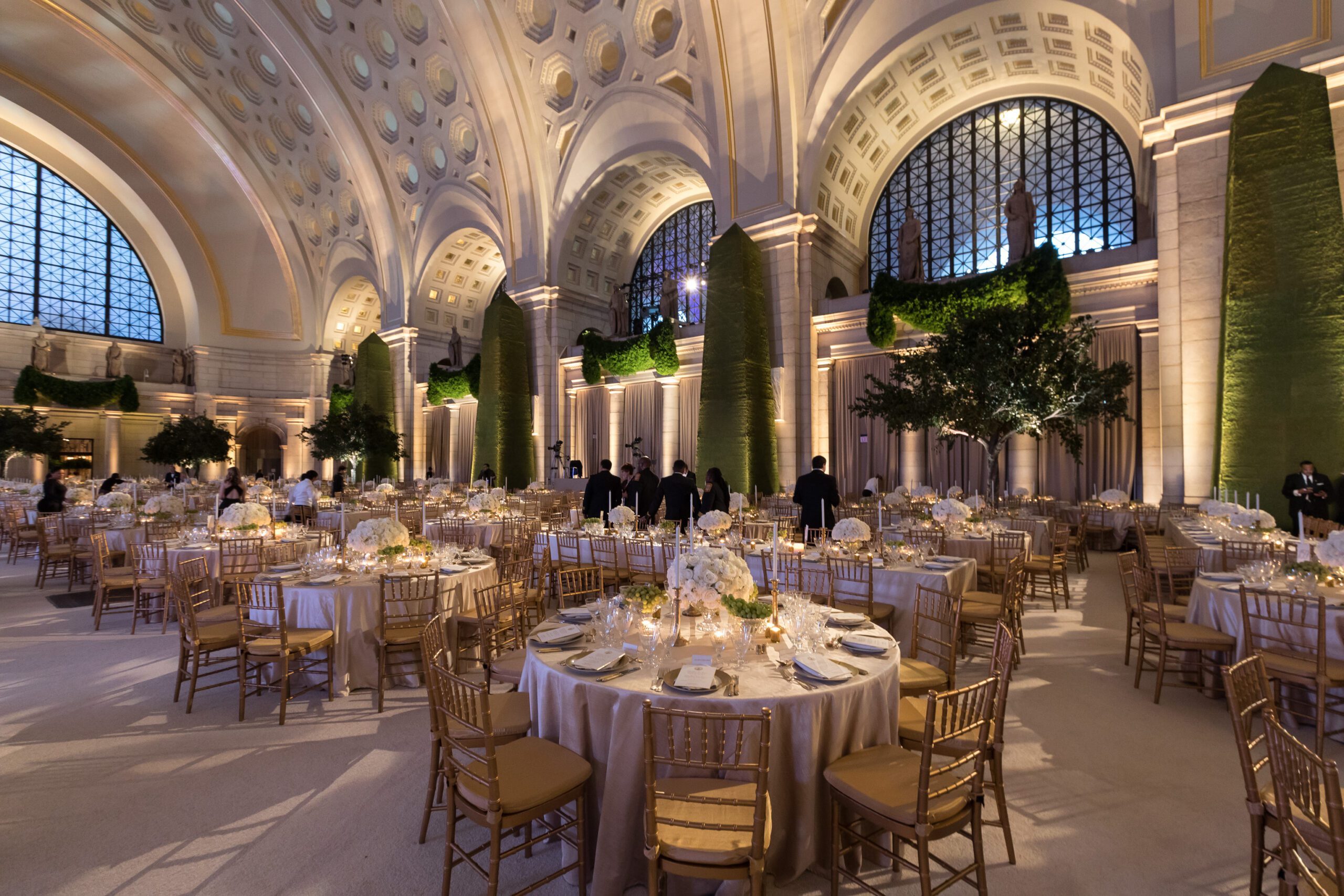 Corporate Event in Main Hall-East with Trees, Hanging Greenery, Floral Centerpieces, and Candlelight.