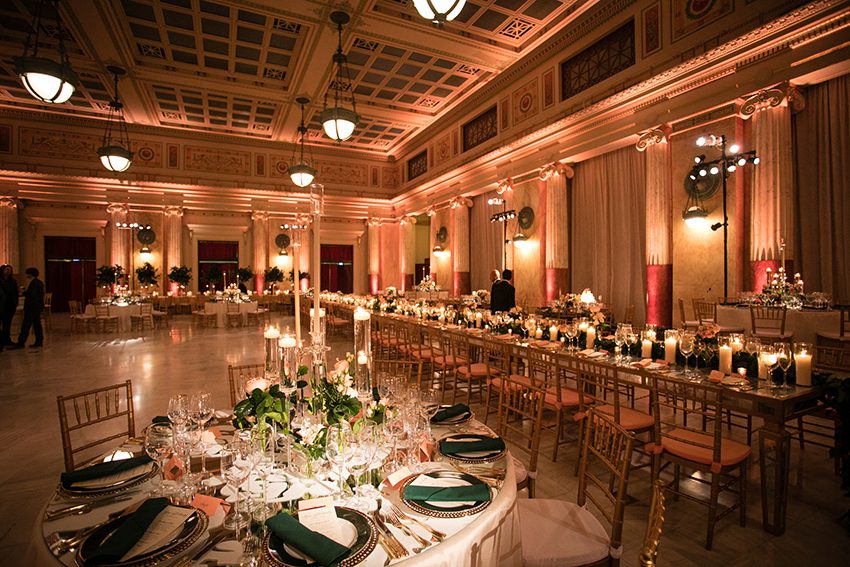 Wedding Served Dinner set in East Hall featuring Standard Round Seating, and a large Gold Mirrored Community Table.