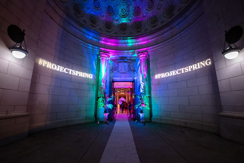 Presidential Suite Outdoor Entrance Customized for a Corporate Event; with Light Projected Branding, a White Carpet, and Colorful Neon Up-Lighting.